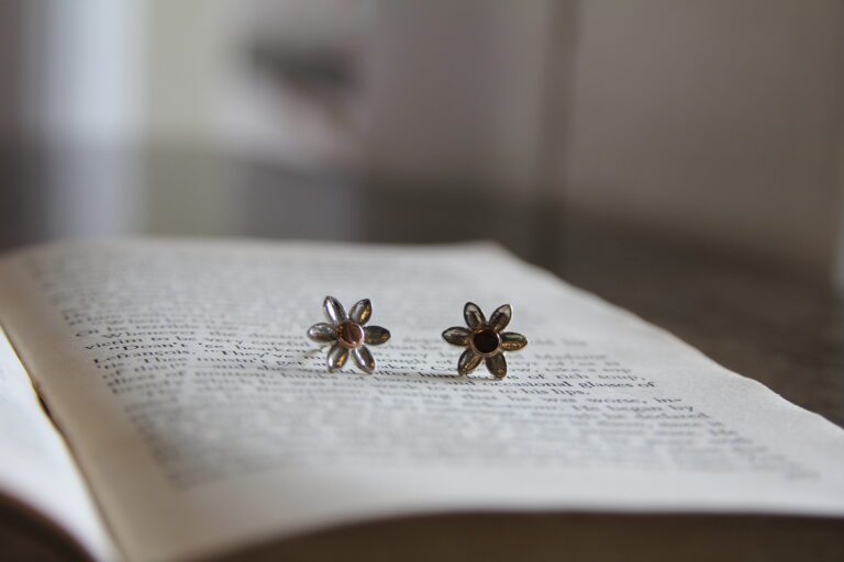 Daisy stud earrings on an old book. The studs are silver for a little bit of rose gold in the middle.